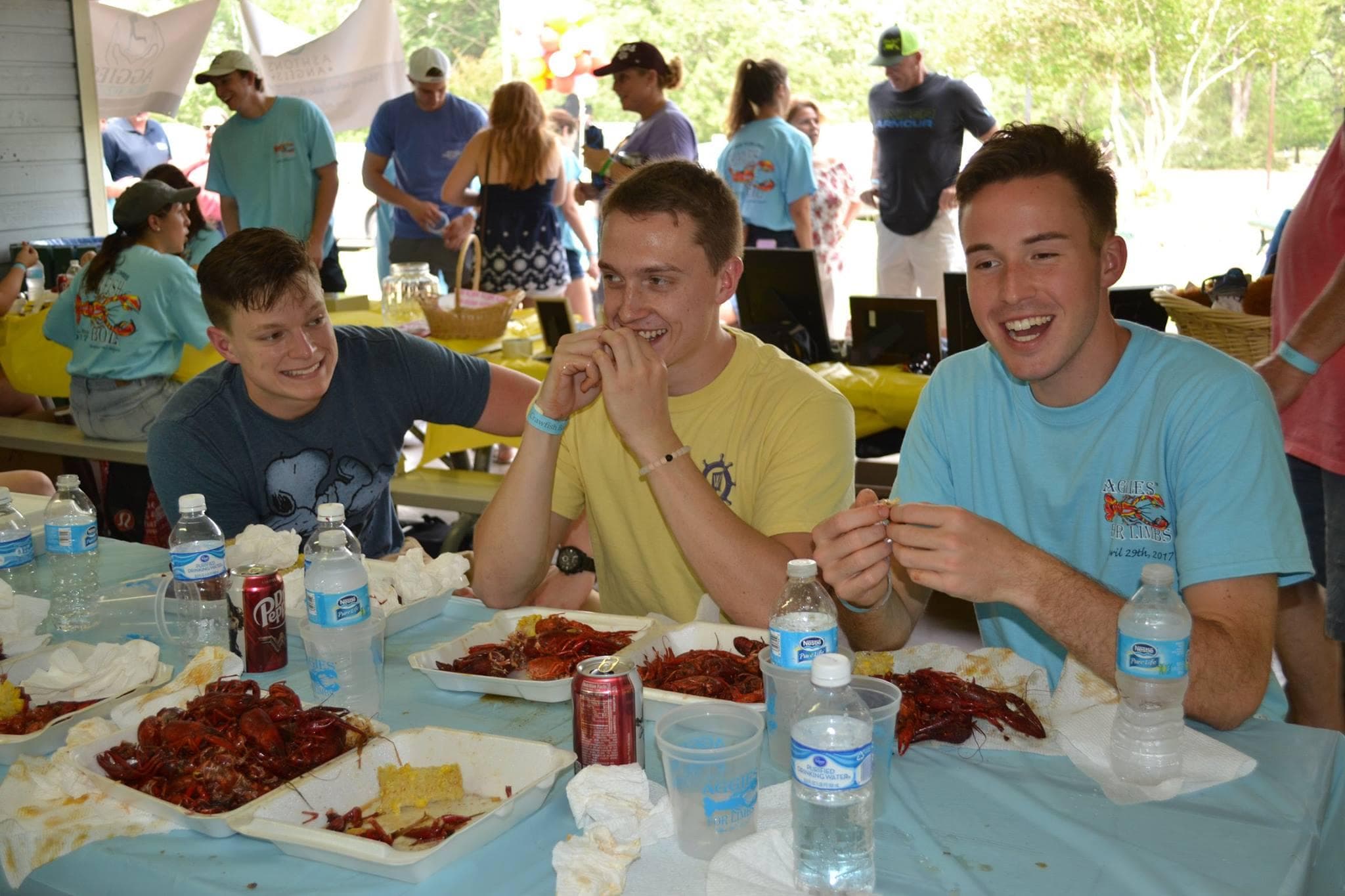 Students enjoying crawfish and refreshments at event tables