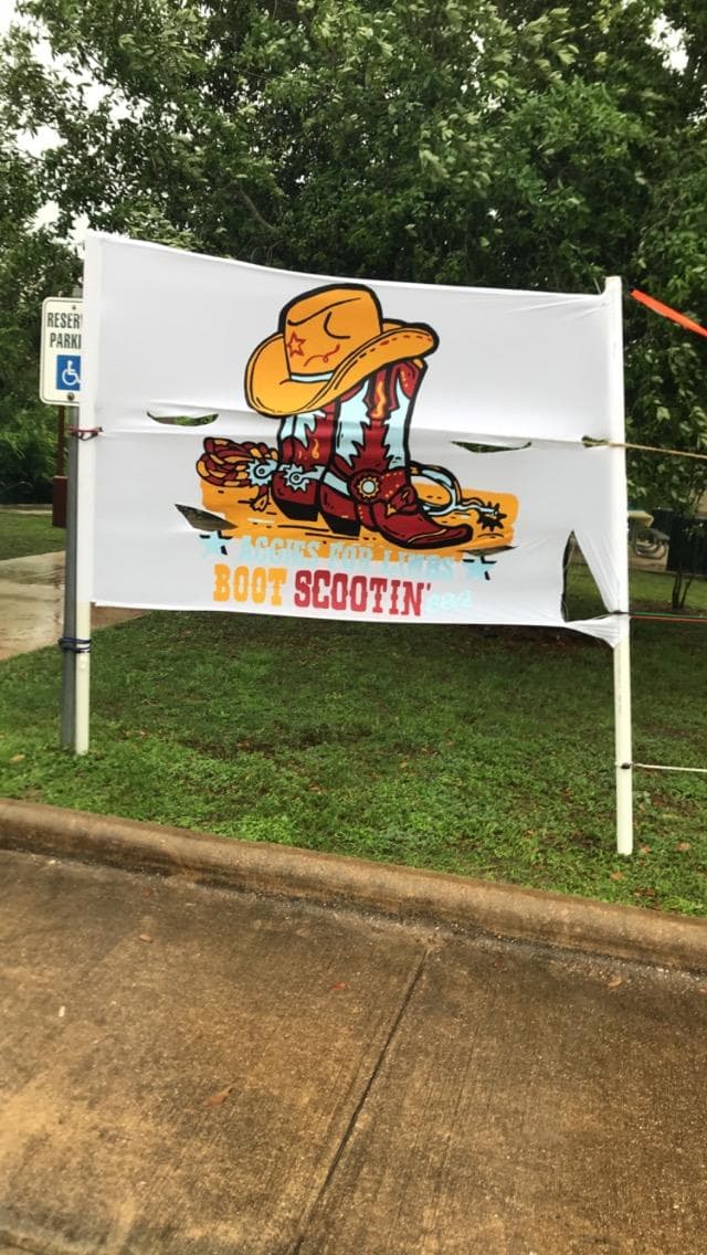Event banner with Boot Scootin' BBQ logo displayed outdoors at the venue
